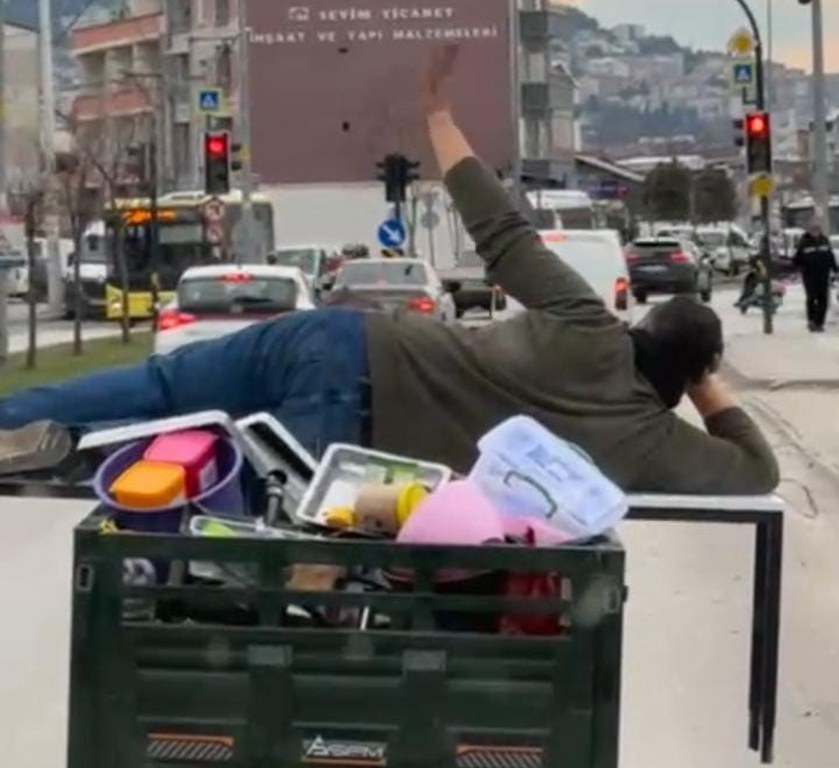 Motosikletin arkasında yatarak tehlikeli yolculuk