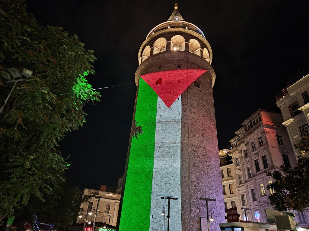 Bayrağı gören yerli ve yabancı turistler, ilgiyle izledi