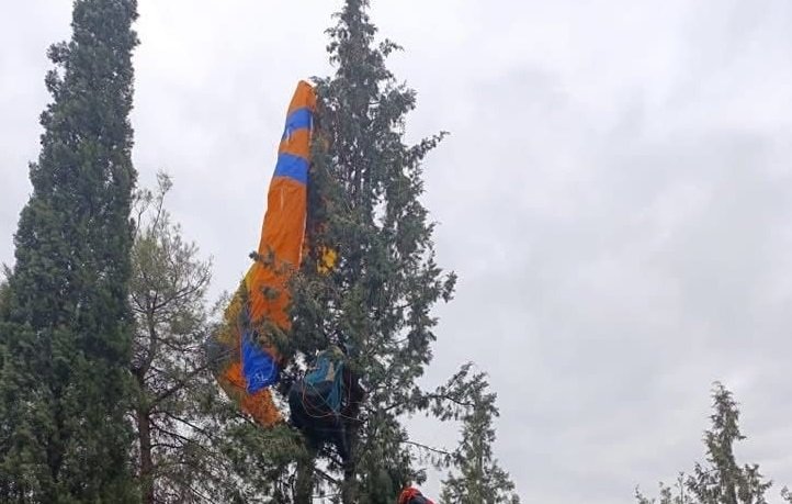 Ağaçta asılı kalan paraşütçüyü itfaiye kurtardı